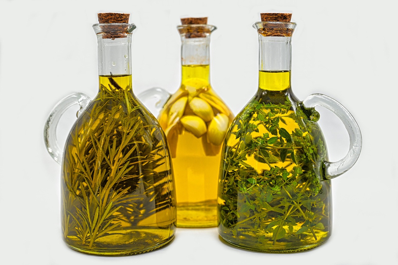 Bottiglie di vetro con erbe in infusione, come si presenta un liquore alle erbe fatto in casa